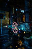 Colorful pipes and valves glowing under UV light, a quirky industrial scene.