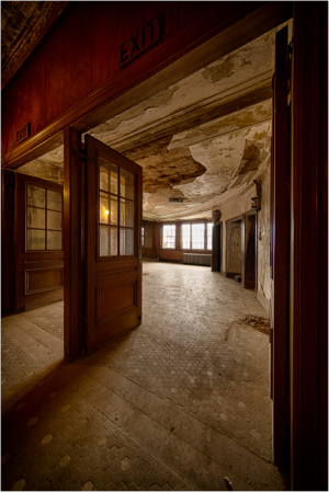 Decaying interior of the Victory Theater with exit signs, haunting atmosphere.
