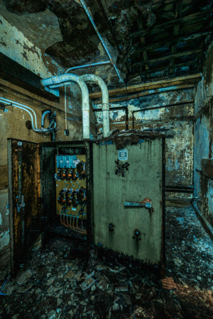A decrepit electrical box in a haunted, crumbling theater basement.