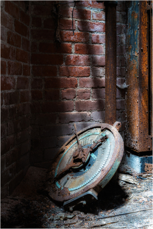 Rusty gauge leaning against weathered brick, hinting at forgotten tales of time.