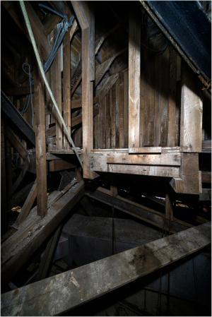 Exposed wooden structural framework of a theater's attic space.
