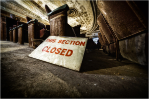 Sign saying 'THIS SECTION CLOSED' near old theater seats, adding to the eerie vibe.