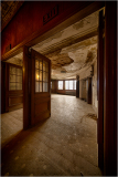 Decaying interior of the Victory Theater with exit signs, haunting atmosphere.