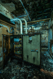 A decrepit electrical box in a haunted, crumbling theater basement.