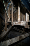 Exposed wooden structural framework of a theater's attic space.