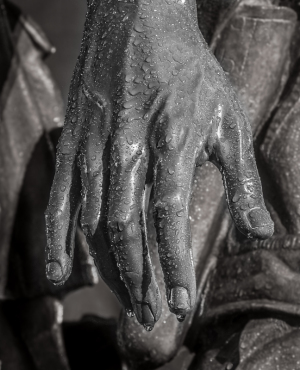 A close-up of a wet, detailed hand with droplets on it.