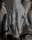 A close-up of a wet, detailed hand with droplets on it.